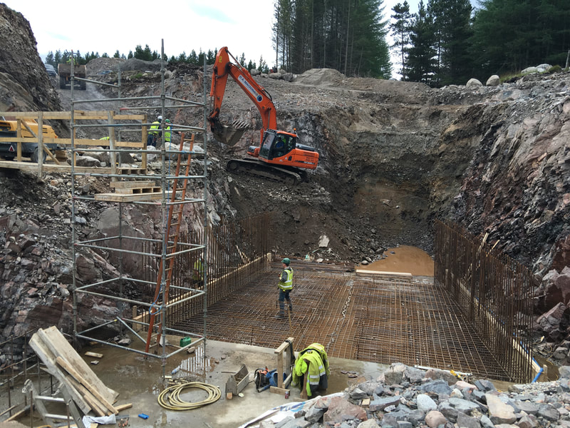 A floor base for the tailrace of a large powerhouse within a huge excavation, In the background is a Doosan dx225 20 ton excavator.