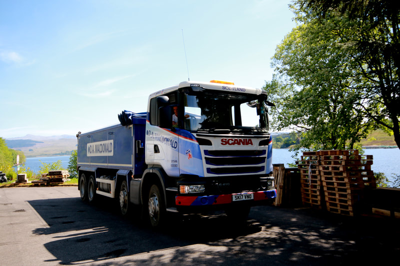 One of our 8 wheeled insulated Scania tipper lorries taken from the front with Loch Awe in the background