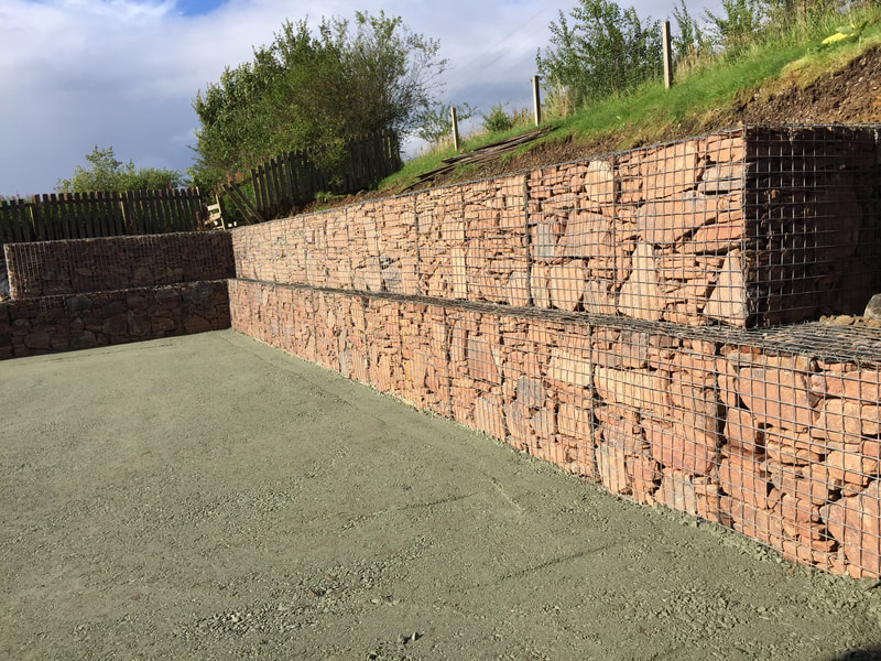 wire gabion baskets filled and faced with red stone, in site retaining a grass bank